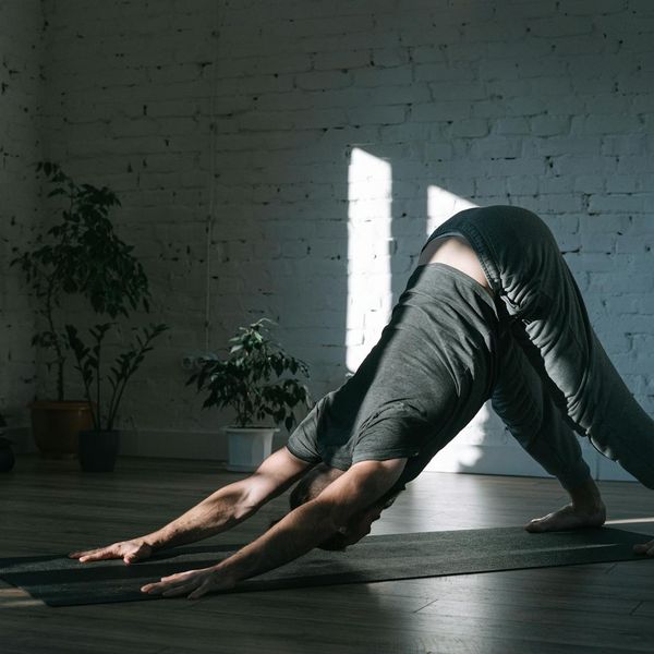 Person stretching in a calm, minimalist environment.